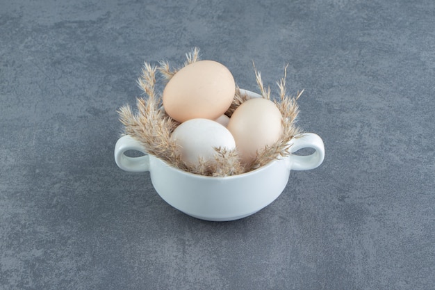 Kostenloses Foto rohe bio-eier im weißen becher