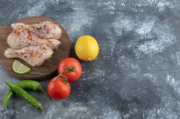 Rohe Bio-Hähnchenschenkel mit Zutaten zum Kochen.