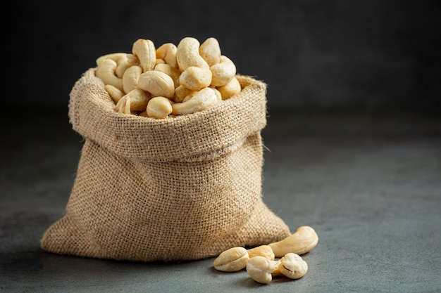 Rohe Cashewnüsse im Beutel auf dunklem Hintergrund