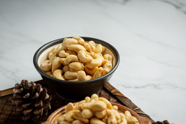 Rohe Cashewnüsse in Schüssel auf Marmorhintergrund