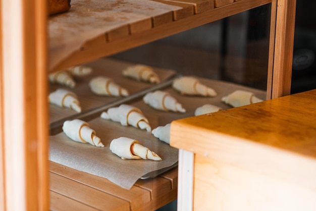 Rohe croissants auf pergamentpapier zum backen vorbereitet