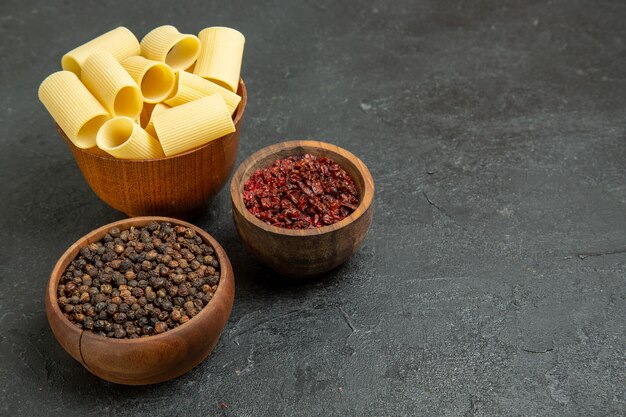 Rohe italienische Pasta der Vorderansicht mit Gewürzen