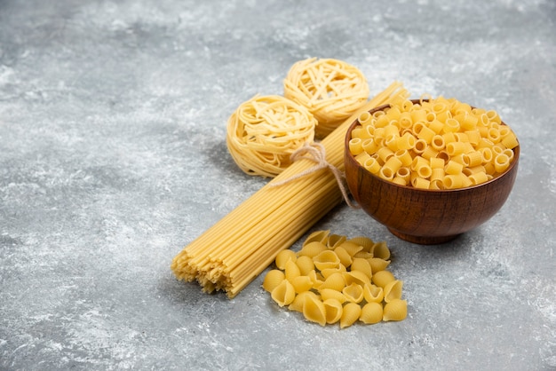 Rohe Nudeln und Spaghetti-Sorten auf Marmortisch.