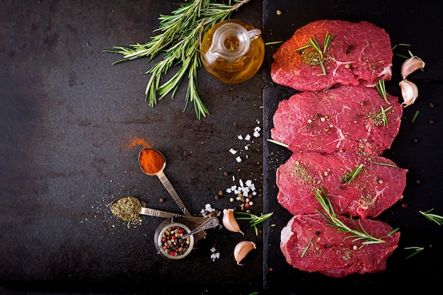 Rohe Rindfleischsteaks mit Gewürzen und Rosmarin. Flach liegend. Draufsicht