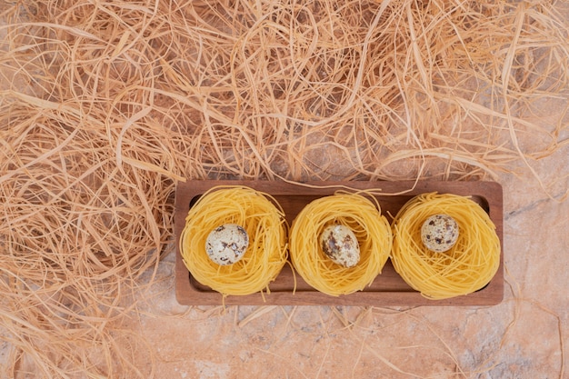 Rohe runde Nudeln mit Wachteleiern auf Marmorhintergrund. Hochwertiges Foto