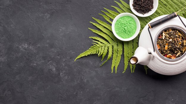 Roher organischer grüner Matchatee in der Schüssel mit trockenem Teebestandteil