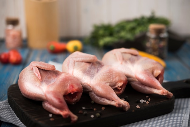 Rohes Huhn auf hölzernem Brett mit Bestandteilen