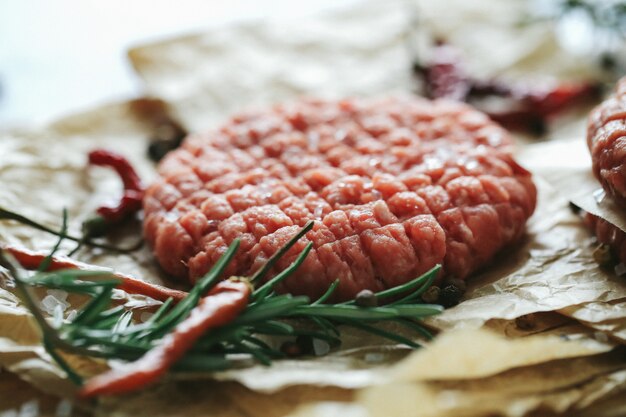 Rohes Rindfleisch Hamburger Pastetchen mit Kräutern und Gewürzen auf dunklem Schiefer Teller