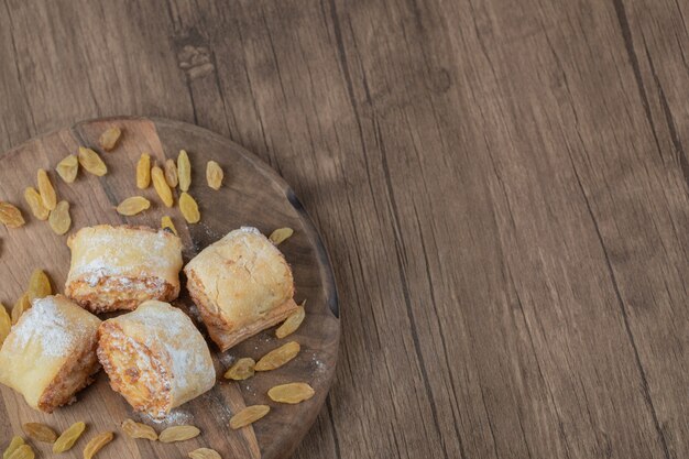 Rollen Sie Kekse mit Rosinen und Füllungen auf einem Holzbrett.