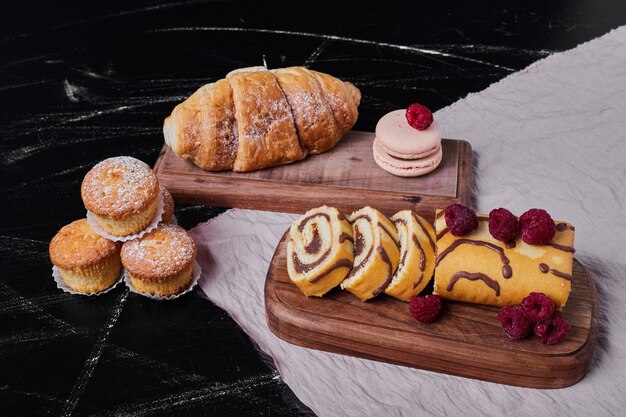 Rollkuchen mit Beeren auf einer Platte mit Muffins.