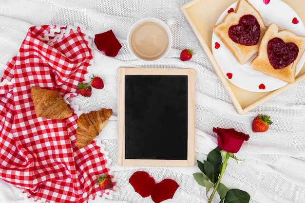 Kostenloses Foto romantische frühstücksanordnung mit leerem brett