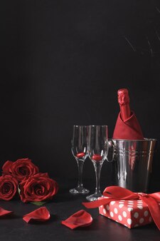 Romantisches dating mit sektgeschenkstrauß aus roten rosen auf schwarzer feier zum valentinstag