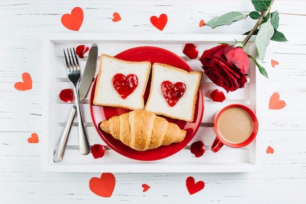 Romantisches Frühstück auf hellem Holztablett