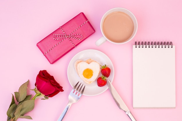 Romantisches Frühstück mit Rose und Geschenk serviert