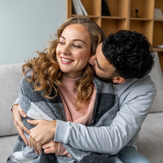 Romantisches Paar auf der Couch zu Hause umarmt