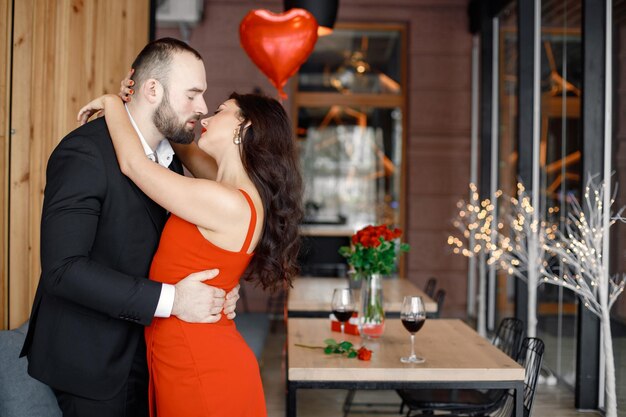 Romantisches Paar, das bei einem Date im Restaurant steht und sich umarmt