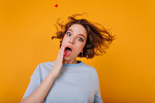 Romantisches weißes Mädchen im blauen T-Shirt, das Spaß während des Fotoshootings hat