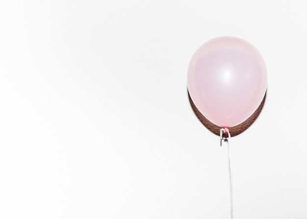 Kostenloses Foto rosa ballon des geburtstages mit schatten gegen weißen hintergrund