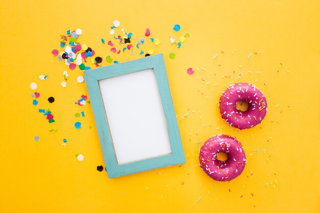 Rosa Donut und Rahmen mit copyspace auf gelbem Hintergrund