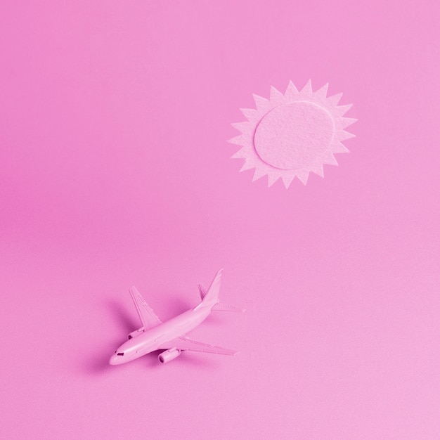 Rosa Hintergrund mit Flugzeug und Sonne