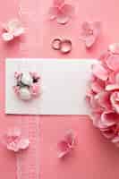 Kostenloses Foto rosa hochzeitsblumen und eheringe des luxushochzeitskonzepts