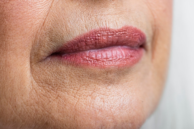 Rosa Lippen der reifen Frau der Nahaufnahme