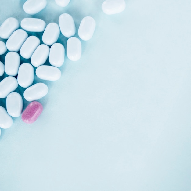 Rosa Pillen mit weißen Tabletten über dem blauen Hintergrund