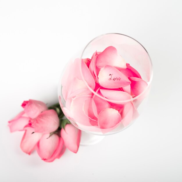 Rosa Rosenblumenblätter im Glas auf Tabelle