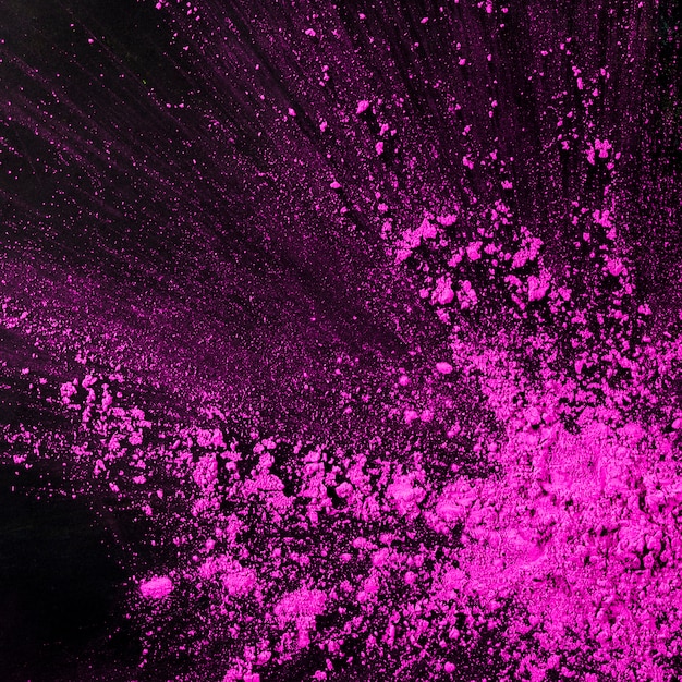 Rosa Staubpartikel spritzen gegen schwarzen Hintergrund