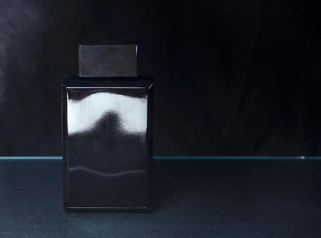 Rosa und blaue parfümflasche mit reflexion auf schwarzem hintergrund