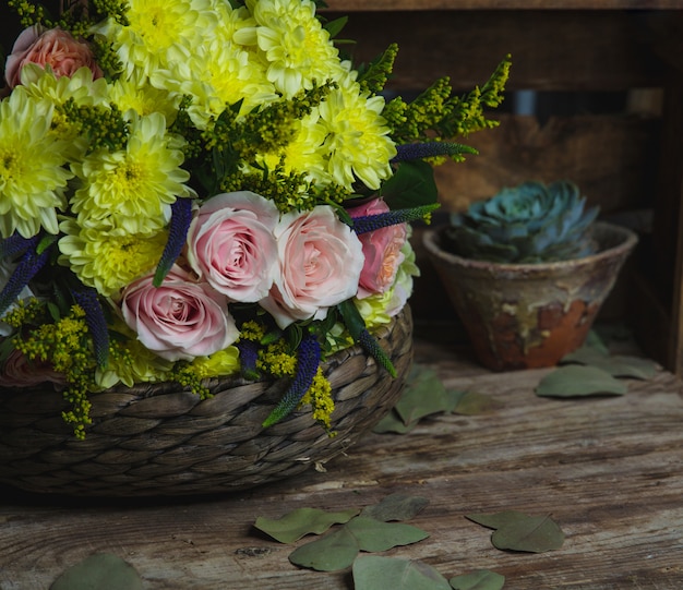 Rosa und gelbe Blumenkombination innerhalb eines Bambusvase.