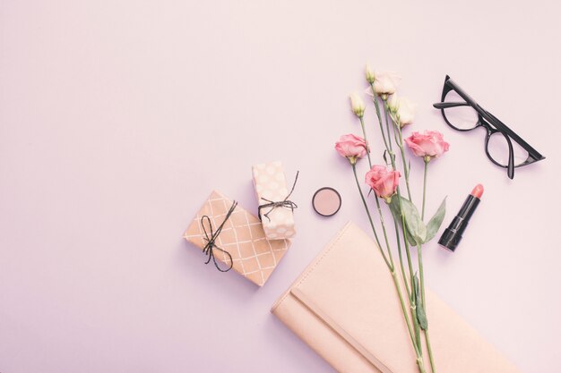 Rosen mit Geschenkboxen und Lippenstift auf dem Tisch