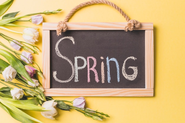 Kostenloses Foto rosen nahe tafel mit frühlingsschreiben