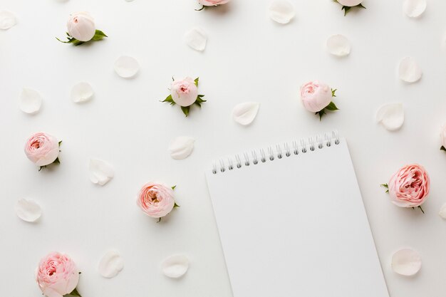 Rosen und Blumenblätter mit Draufsicht des Notizblockes