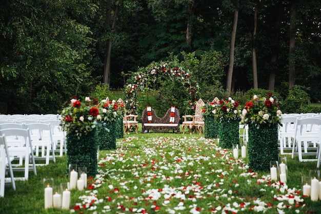 Rosenblumenblätter bedecken den grünen Garten, der zu den traditionellen hindischen weddi bereit ist