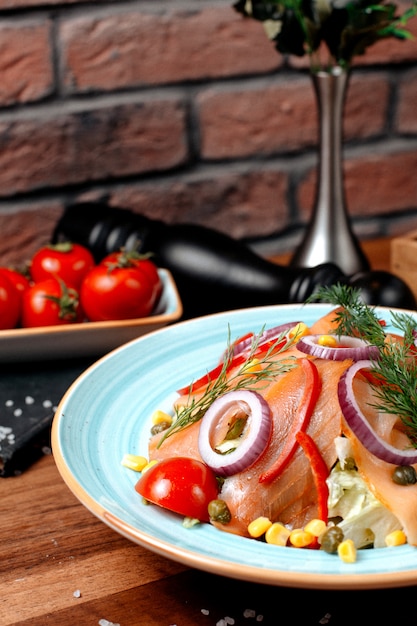 Rot geräucherter Fischsalat der Seitenansicht mit Zwiebelmais und Tomaten