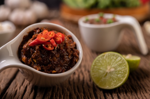 Rote-Augen-Chilipaste mit Zitrone und Chili auf Holzboden.