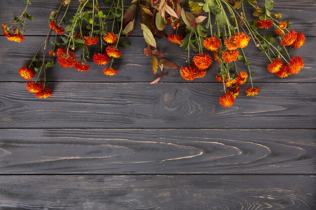 Rote Blumen auf Holztisch verstreut