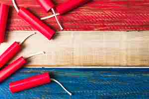 Kostenloses Foto rote dynamitkracher auf hölzernem gemaltem hölzernem plankenhintergrund
