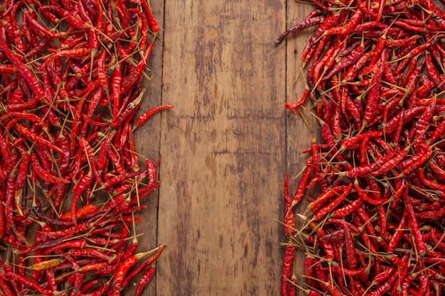 Rote getrocknete paprikas, die auf der planke gestapelt werden.
