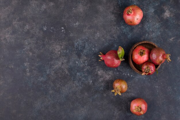 Rote Granatäpfel in einer Holzplatte, Draufsicht