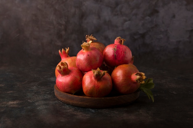 Rote Granatäpfel in einer Holzplatte