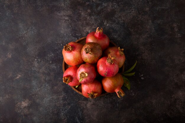 Rote Granatäpfel in einer Platte auf schwarzem Tisch