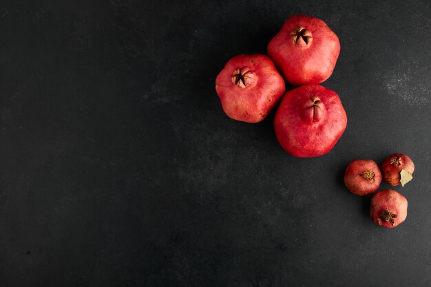 Rote Granatäpfel in kleinen und großen Formen in der oberen Ecke.