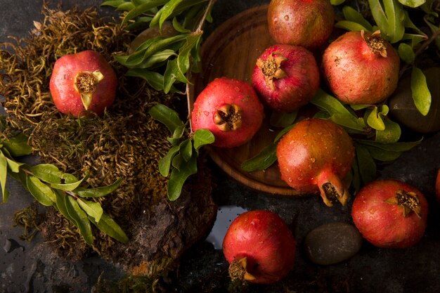 Rote Granatäpfel mit ihren grünen Blättern