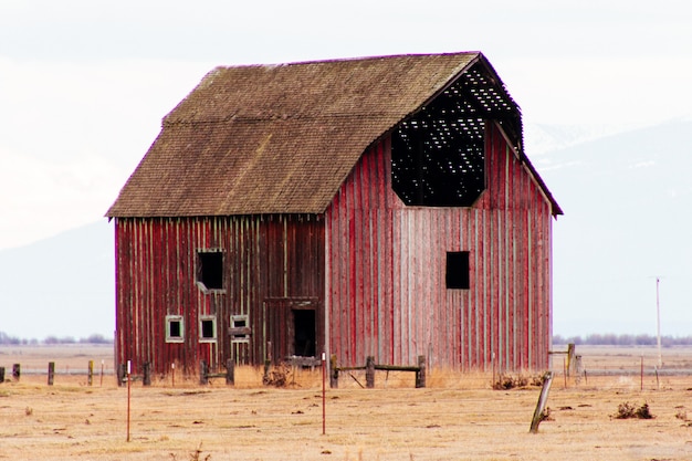 Rote Holzscheune in einem großen Feld