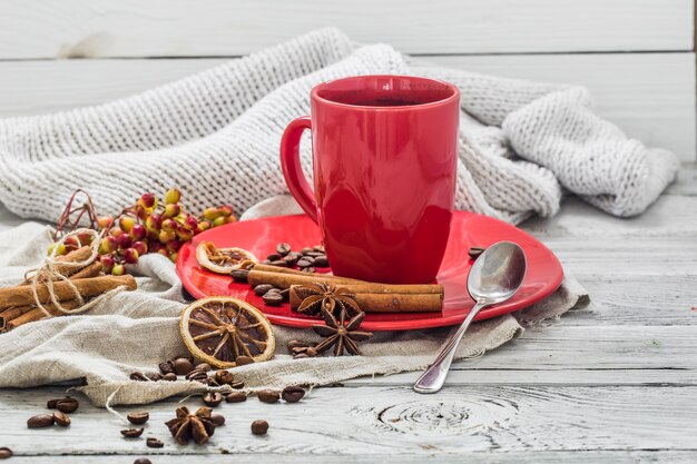 rote Kaffeetasse auf einem Teller, Holzwand, Getränk