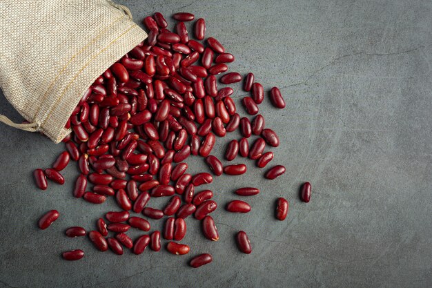 Rote Kidneybohnen fließen aus dem Sackbeutel auf den Boden