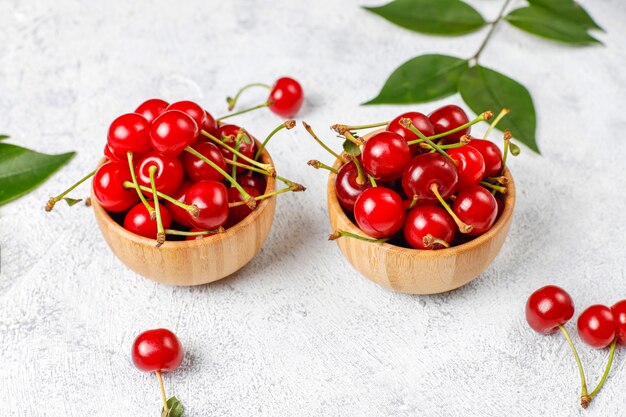 Rote Kirschen in Tellerschale auf grauem Tisch