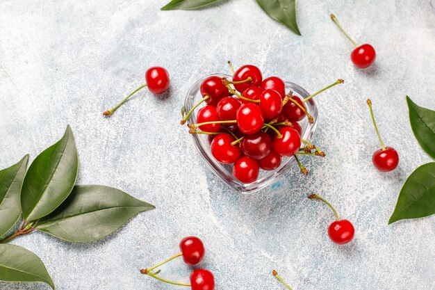 Rote Kirschen in Tellerschale auf grauem Tisch